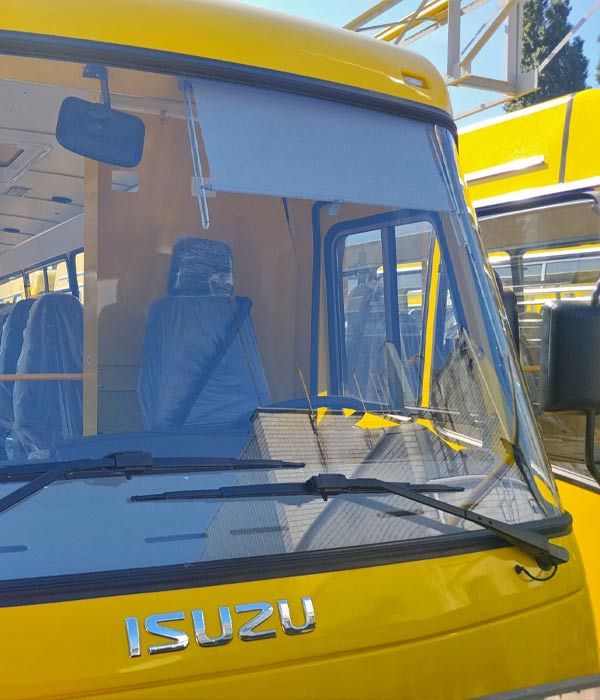 Сонцезахисна ролета PRiS System на лобовому склі автобуса ISUZU після професійного монтажу.